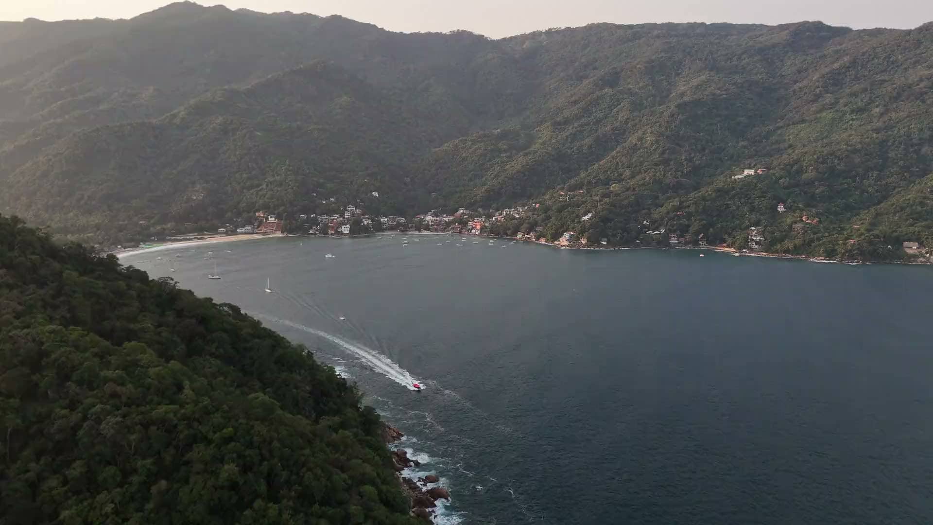 A boat crossing Yelapa Bay below the mountains